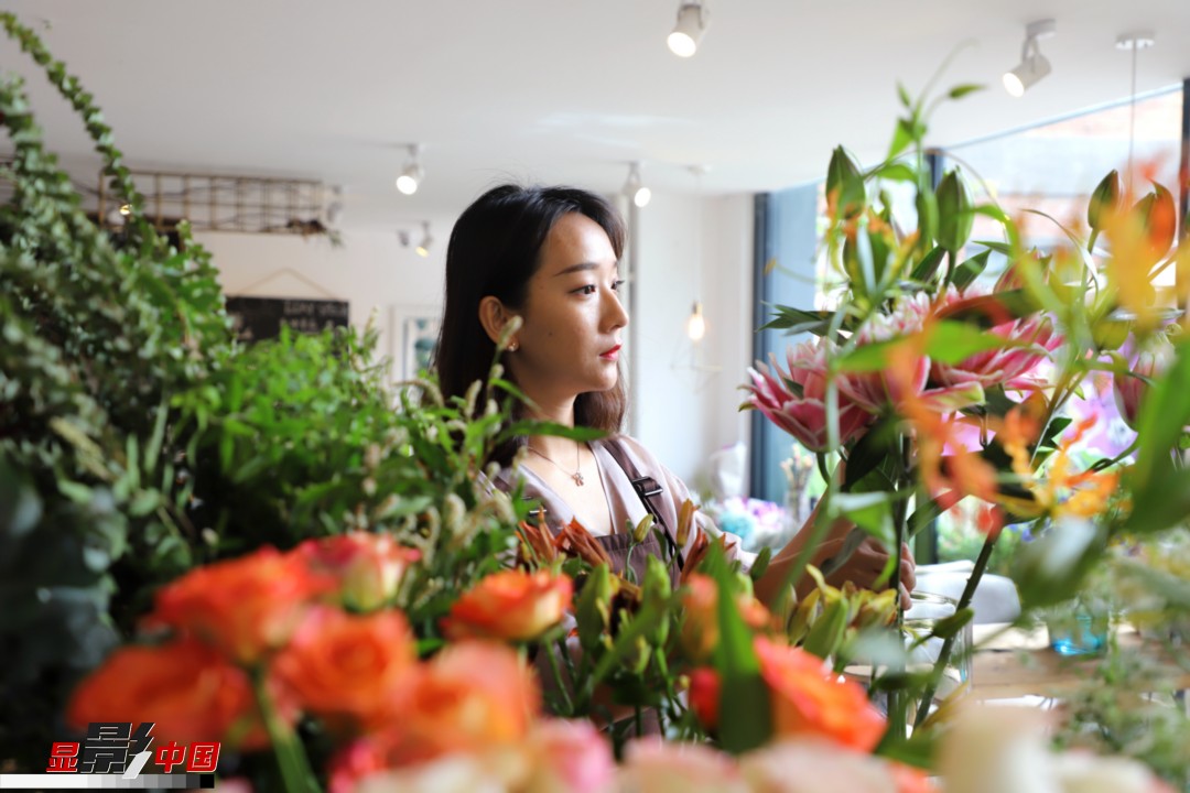 每天和花打交道是一個幸福的職業(yè)，但同時也充滿壓力和挑戰(zhàn)，“花在呈現(xiàn)給客人的那一瞬間是美好的，但前面的每一個步驟都是很辛苦的。”王黎媛說，花藝是最原始的手工藝產(chǎn)品，沒有辦法機(jī)械化、流程化和規(guī)模化，必須要用雙手一點點地賦予其生命和美感。圖為王黎媛在挑選制作花束的鮮花。新華網(wǎng) 周亞平/攝 念新洪/文